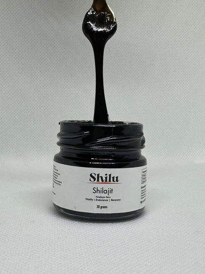 Jar of Shilajit nz with a spoonful being poured over it on a gray background